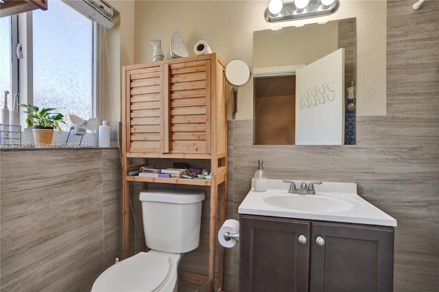 bathroom featuring tile walls, vanity, and toilet