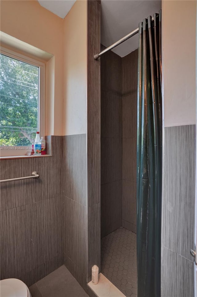 bathroom with toilet and a tile shower