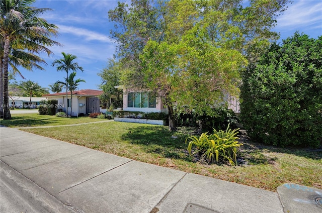 obstructed view of property with a front yard