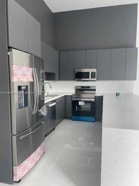 kitchen with gray cabinets, sink, and stainless steel appliances