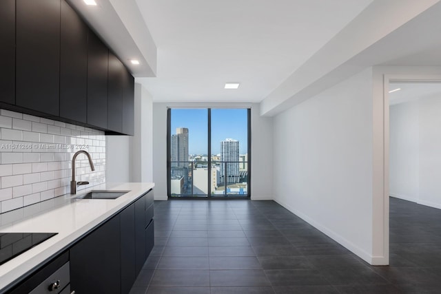 kitchen featuring sink, dark tile flooring, backsplash, black electric cooktop, and floor to ceiling windows