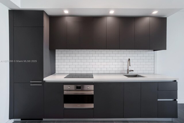 kitchen with backsplash, dark tile floors, dark brown cabinetry, and sink