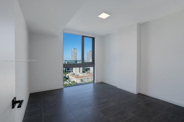 tiled spare room featuring floor to ceiling windows