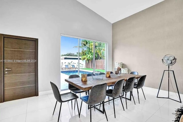 tiled dining area featuring high vaulted ceiling