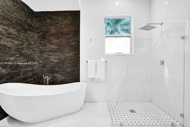 bathroom with tile walls, tile floors, and plus walk in shower