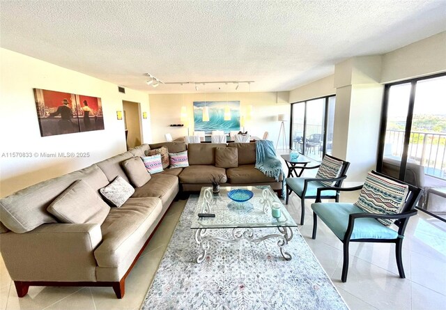 tiled living room with a textured ceiling and rail lighting