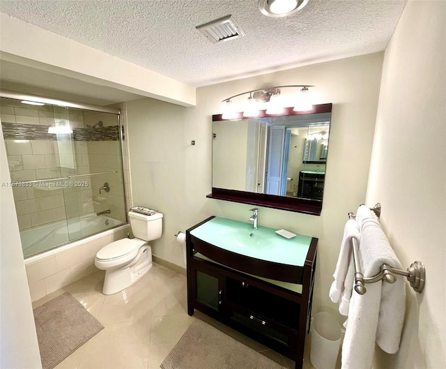 full bathroom with toilet, enclosed tub / shower combo, vanity, tile patterned floors, and a textured ceiling