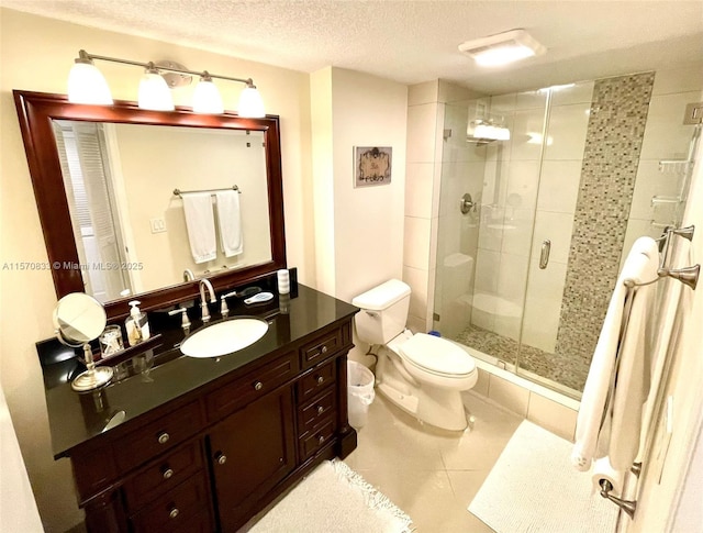 bathroom with toilet, vanity, tile patterned floors, a shower with door, and a textured ceiling