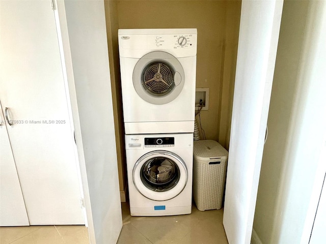 laundry room with stacked washing maching and dryer and light tile patterned flooring