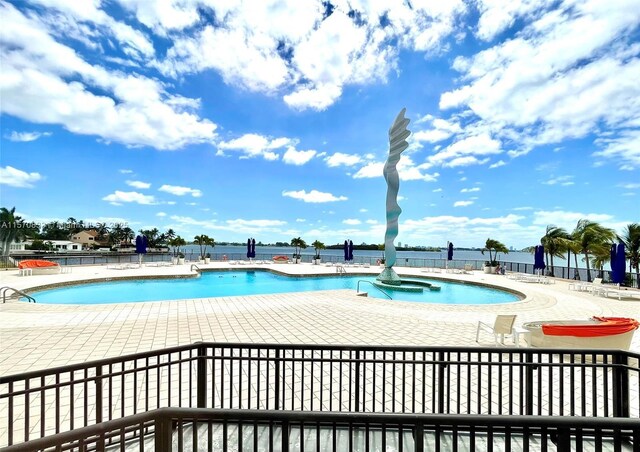 view of pool featuring a patio and a water view