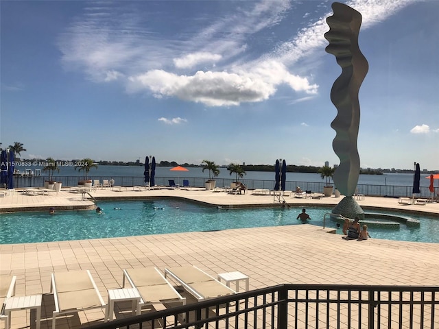 view of swimming pool featuring a patio area, a hot tub, and a water view