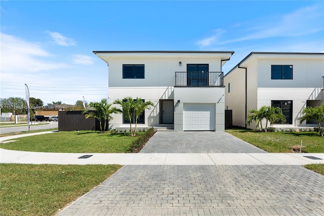 view of front facade with a garage, a balcony, and a front lawn