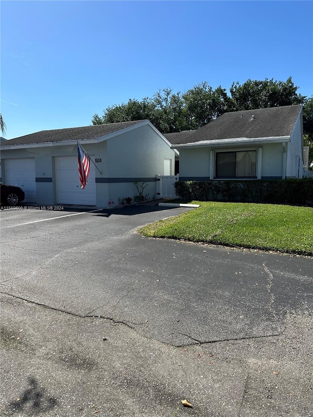 ranch-style home with a garage and a front yard