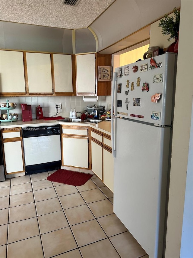 kitchen featuring white cabinets, light tile flooring, white appliances, and backsplash