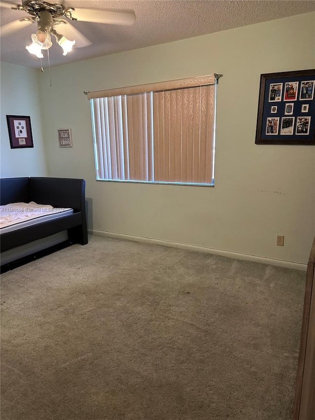 carpeted bedroom featuring a textured ceiling and ceiling fan