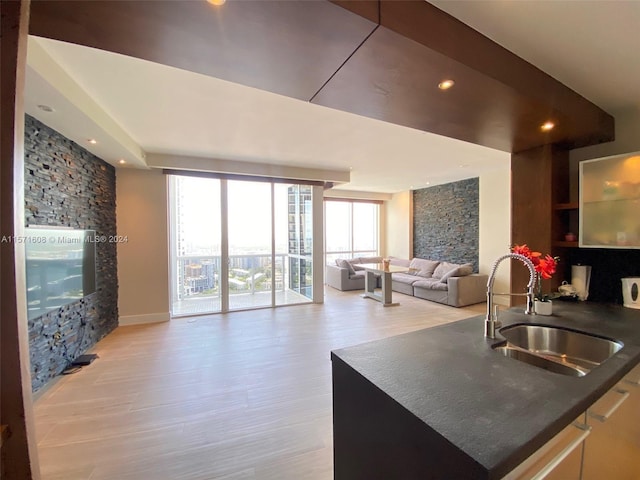 kitchen featuring floor to ceiling windows, light hardwood / wood-style floors, and sink