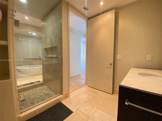 bathroom with vanity, tile patterned floors, and shower with separate bathtub