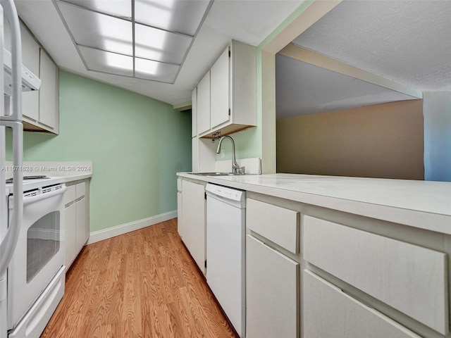 kitchen featuring sink, light hardwood / wood-style floors, white cabinetry, stove, and white dishwasher