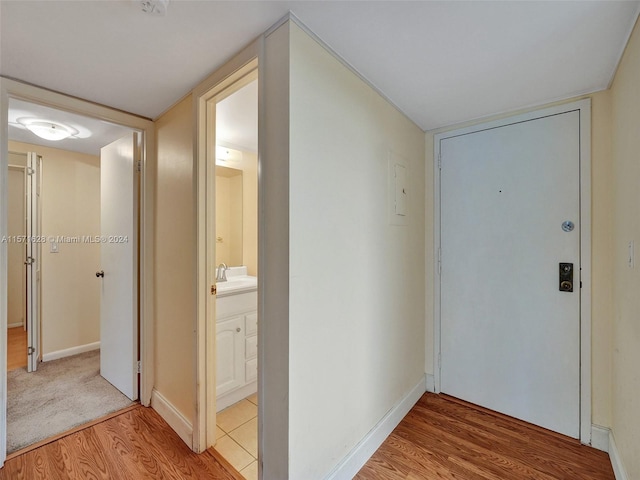 corridor with light carpet and sink