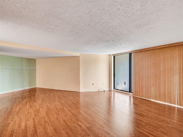 empty room featuring light hardwood / wood-style flooring and a textured ceiling