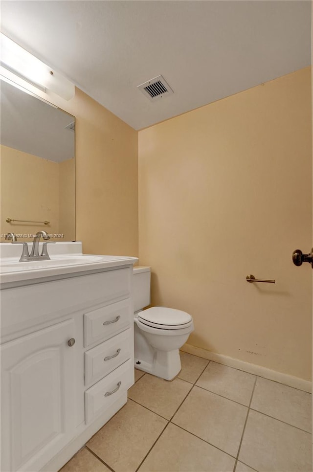 bathroom featuring tile flooring, vanity, and toilet