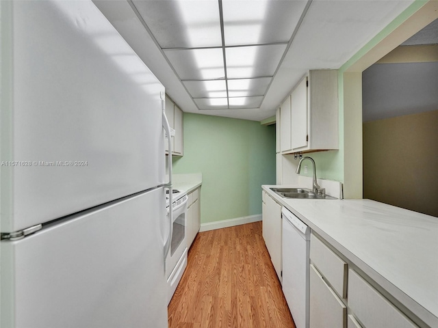 kitchen featuring sink, white appliances, light wood-type flooring, and white cabinetry