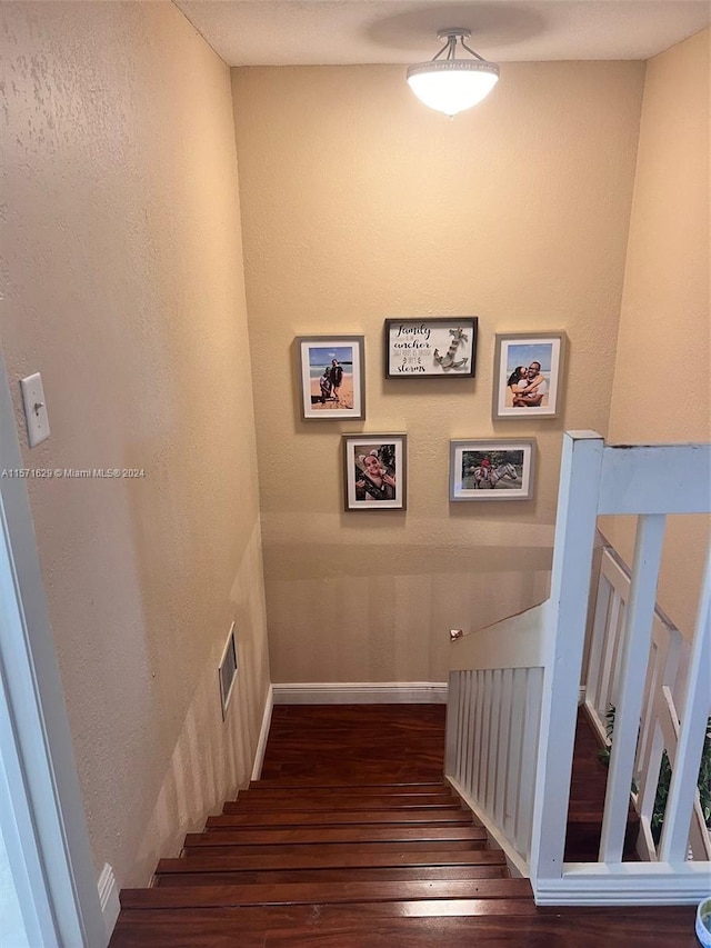 staircase with dark wood-type flooring