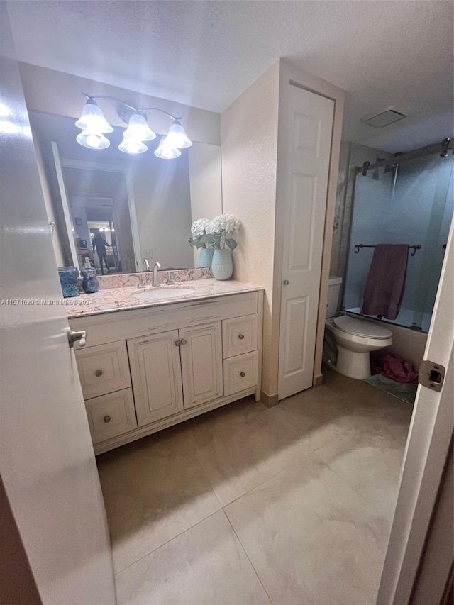 bathroom featuring vanity, a textured ceiling, and toilet