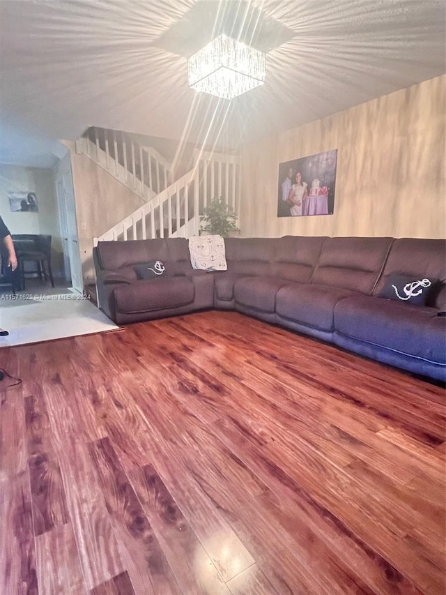 unfurnished living room with a chandelier and hardwood / wood-style flooring