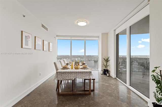 dining room featuring a water view and expansive windows