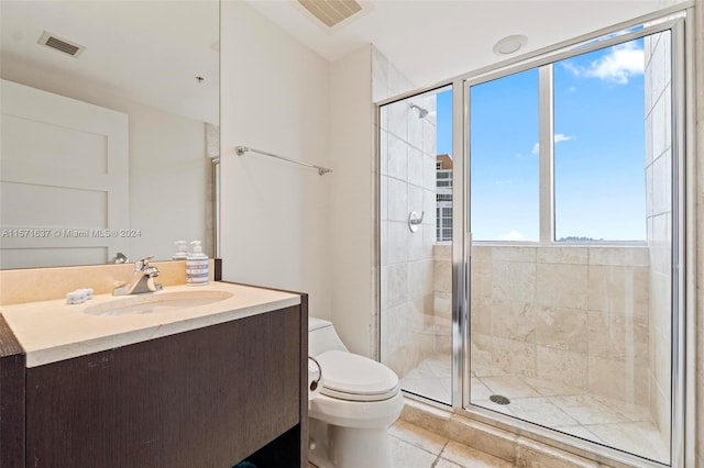 bathroom featuring tile patterned floors, vanity, a shower with door, and toilet