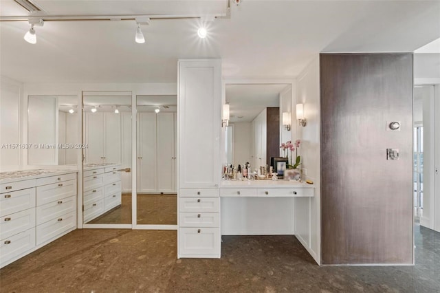 bathroom with vanity, track lighting, and concrete floors