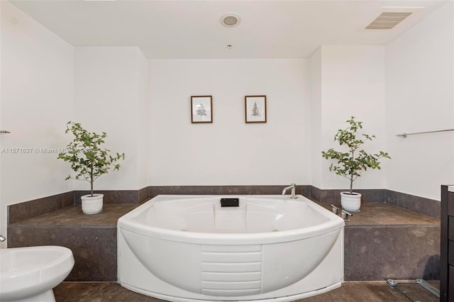 bathroom featuring tile patterned floors, a tub to relax in, and a bidet