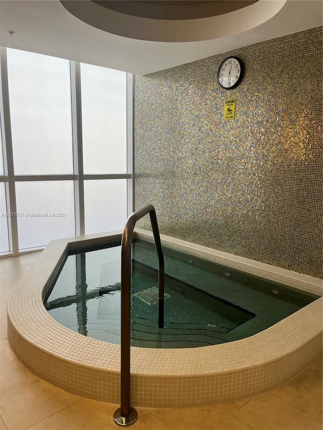 view of swimming pool with an indoor hot tub