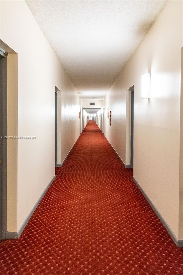 hallway featuring dark carpet