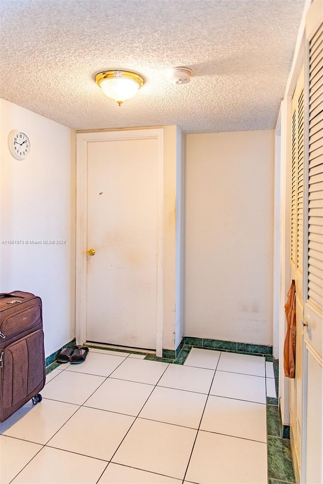 doorway featuring tile flooring and a textured ceiling