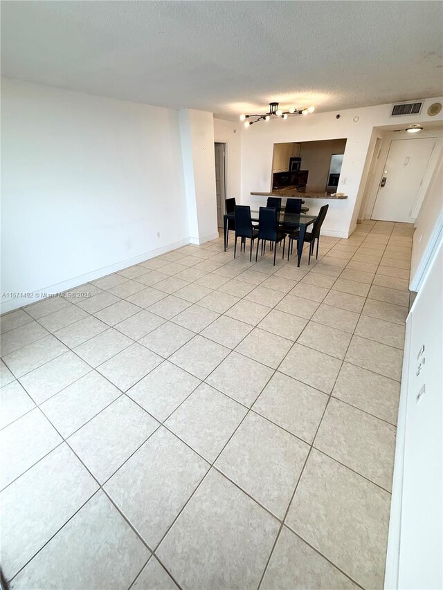 tiled living room featuring a textured ceiling