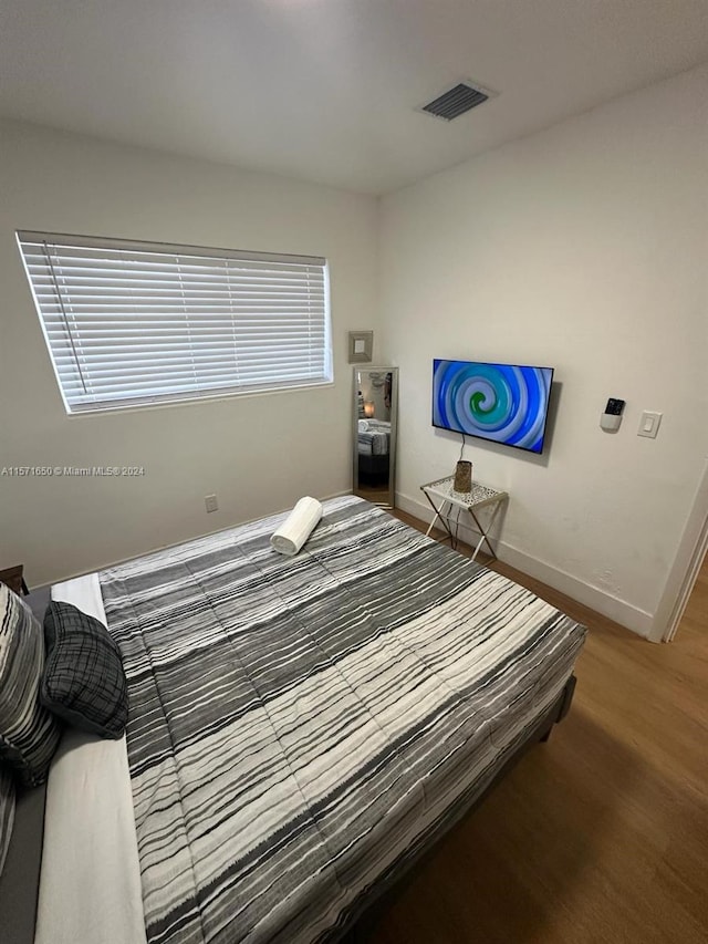 bedroom with dark hardwood / wood-style flooring