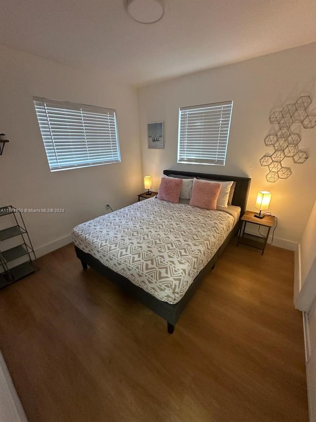 bedroom with dark hardwood / wood-style flooring