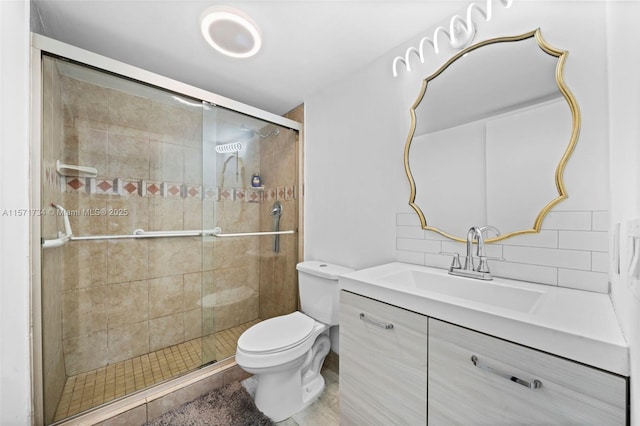 bathroom featuring decorative backsplash, a shower with door, vanity, and toilet