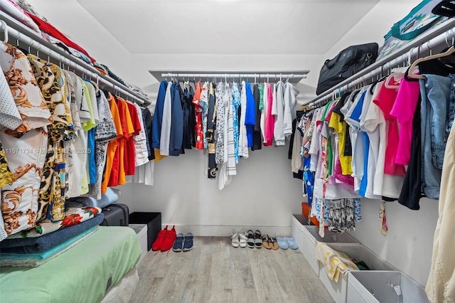 walk in closet with light hardwood / wood-style flooring