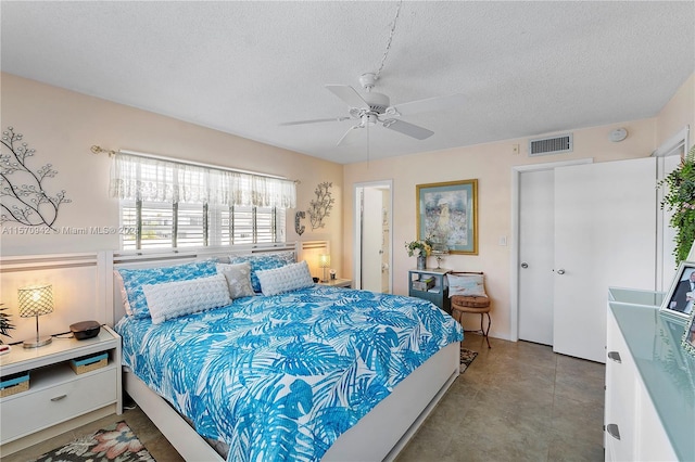 bedroom with ceiling fan and a textured ceiling