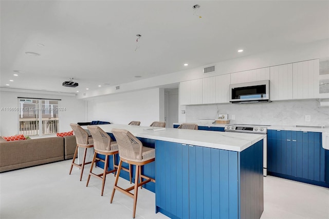 kitchen with backsplash, a kitchen breakfast bar, electric stove, and white cabinets