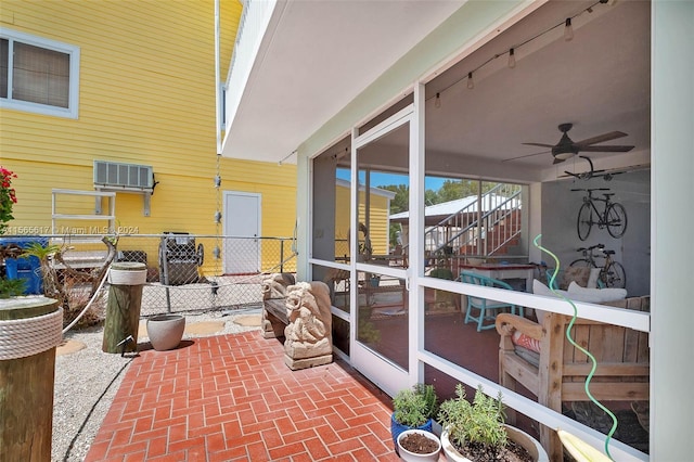 sunroom featuring ceiling fan and track lighting