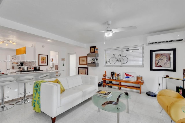 living room with a wall unit AC and ceiling fan