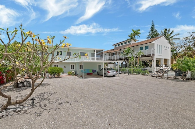 back of house featuring a carport and a balcony