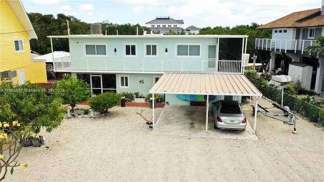 rear view of property featuring a carport and a balcony