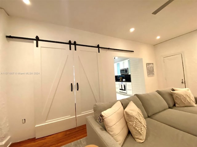 interior space with hardwood / wood-style flooring, a barn door, and ceiling fan