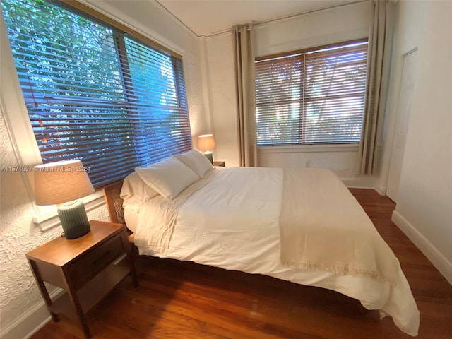 bedroom with dark hardwood / wood-style flooring