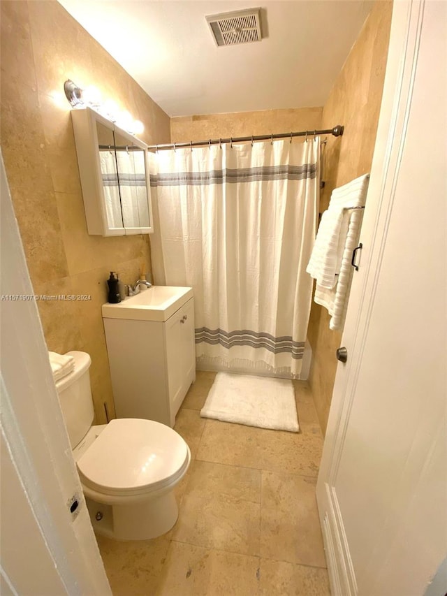 bathroom with vanity, tile floors, and toilet